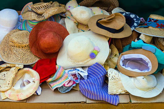 Messy pile of colourful summer female hats outside on street market