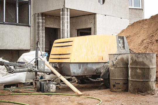 Construction site equipment rests near a building under development during overcast afternoon light
