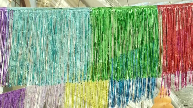 colorful tinsel garland hanging in rows for festive decoration. shiny foil garland creates joyful atmosphere for party celebration. bright garland is perfect decor for any holiday event