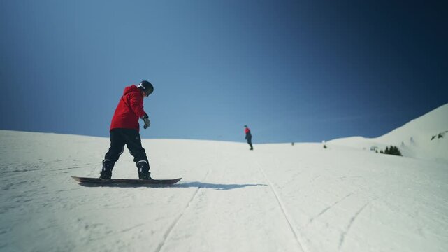 Two snowboarders glide down a pristine, snow-covered mountain slope. The scene beautifully captures winter sports and outdoor adventure.