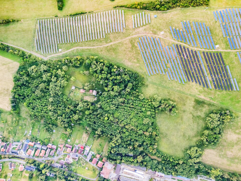 Aerial view of Jakubovany in Liptov featuring a large solar farm installation adjacent to a dense forest and residential area in Jakubovany, Zilina Region, Slovakia.