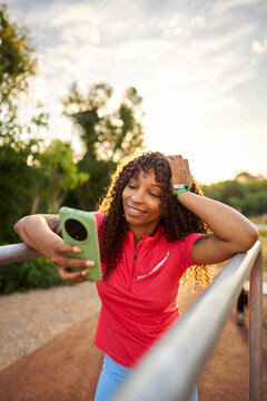 Smiling woman checking smartphone after outdoor workout