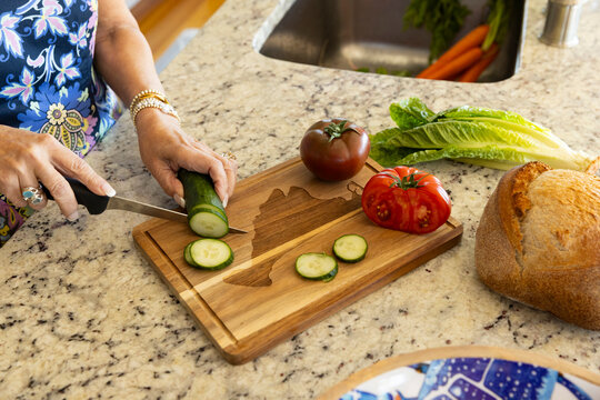 Woman cut vegetables on cutting board 