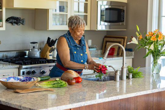Senior Black black woman prepare meal kitchen home 