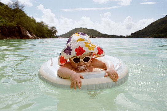 A toddler enjoys time spent in the ocean with an inflatable ring.