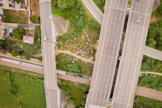 Aerial view of Eastern Peripheral Expressway with multi-lane highway sections, a railway track running underneath, and surrounding green fields in Sonipat, Haryana, India.