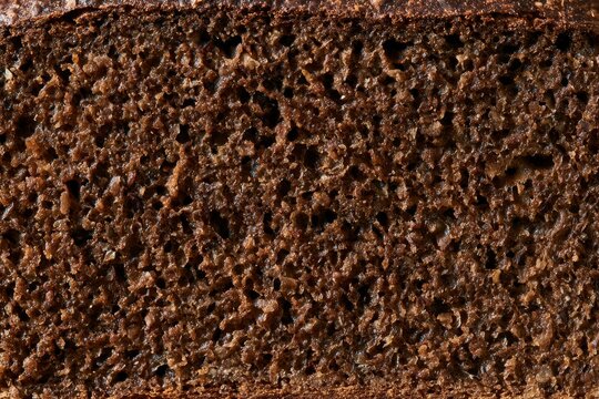 Freshly baked rye bread cut in half showing the dark crumb inside