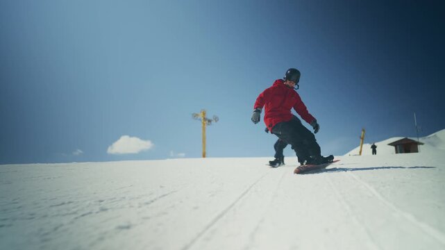 Two snowboarders carve down a snowy mountain slope. They are enjoying the exhilarating winter sports and clear blue sky.