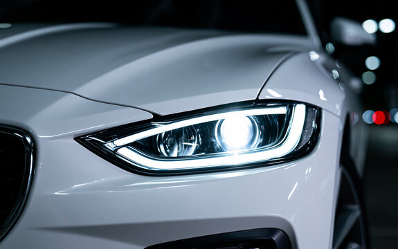 Closeup shot of led headlights of a white car lighting up when starting the car LOG