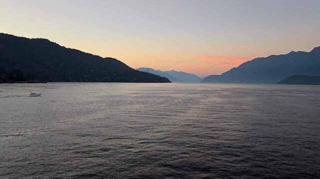 Howe Sound sunset with orange and red skies and clouds with Bowen Island in the foreground - Canada travel and tourism