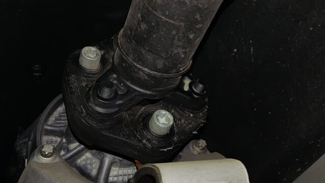 A rubber flexible coupling disc connecting a car driveshaft to the differential housing.