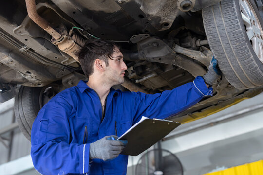 Mechanic repairs car engine in garage