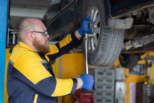 Mechanic changing wheel at the garage