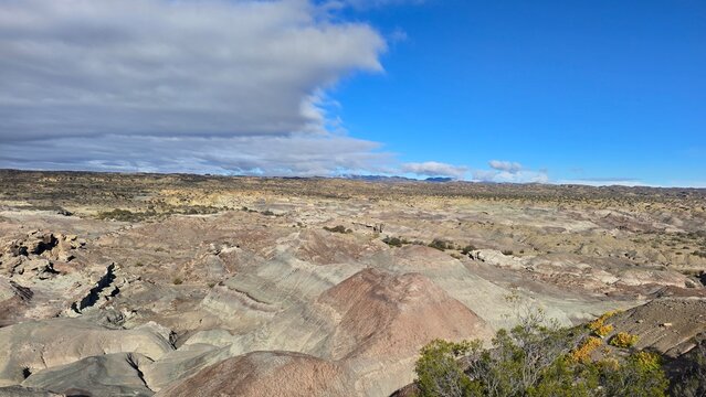 Wide panoramic view of eroded badlands under a divided sky in Ischigualasto.