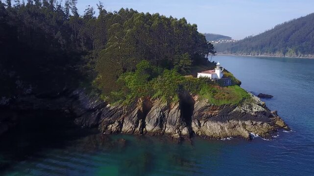 Vuelo sobre faro abri&eacute;ndose el plano a playa