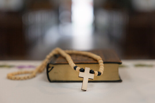 Holy mass at the altar in a catholic church. Holy Bible and Rosary detail on altar.