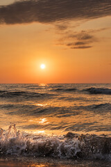 Obraz premium Golden Sunset Over Foamy Ocean Waves