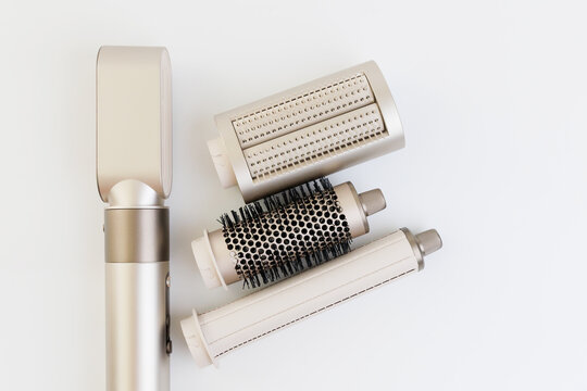 Small hair styling tool with multiple attachments on a white background