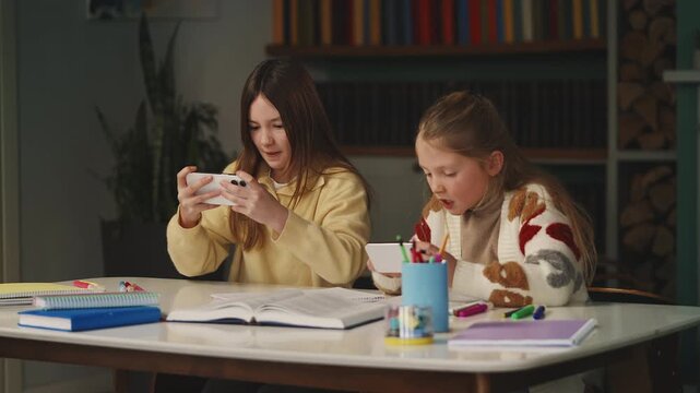 Two young friends play educational games on phones, interactive digital learning