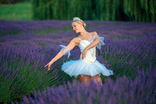 A ballet white dancer gracefully poses among blooming lavender fields