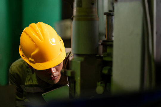 Engineering technician worker is operating the machine in the factory using touch screen computer monitor to command order for line production and steel industry