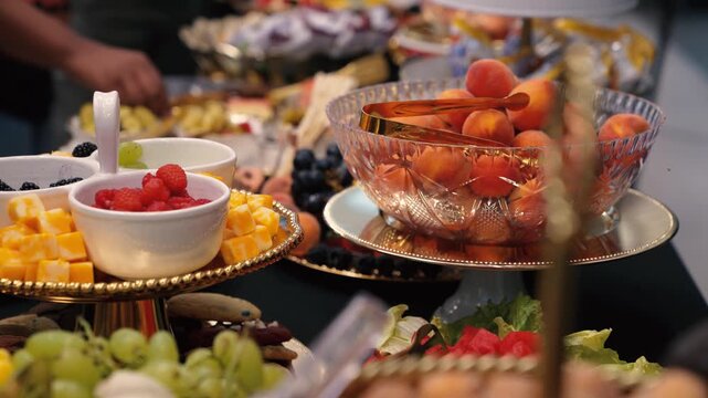Hands reach in on fruit and cheese buffet