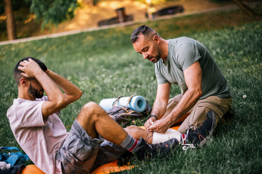 Hiker receiving first aid for an injured ankle during an outdoor trip