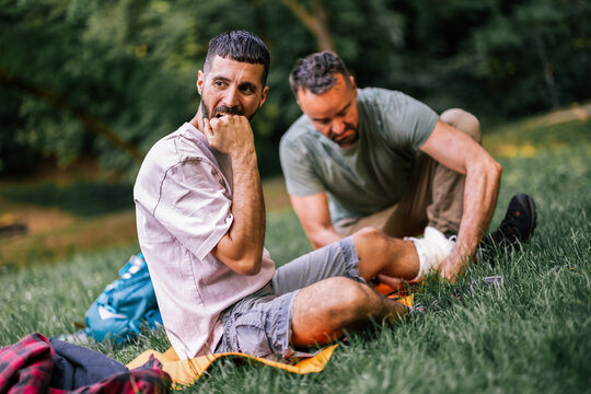 Hiker resting with a companion while receiving treatment for an ankle injury