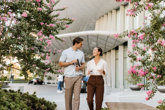 Couple enjoying a sunny day while walking among blooming flowers