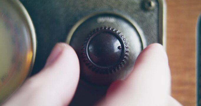 Close up shot of knob turning for changing volume on a vintage radio