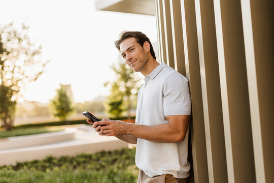 Man enjoying a peaceful moment while texting outside in the golden sunlight