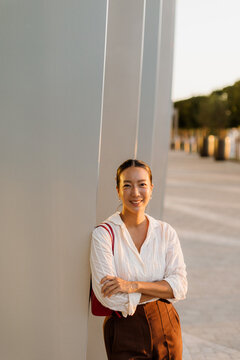 Korean woman enjoys a sunny evening by modern architecture in the city