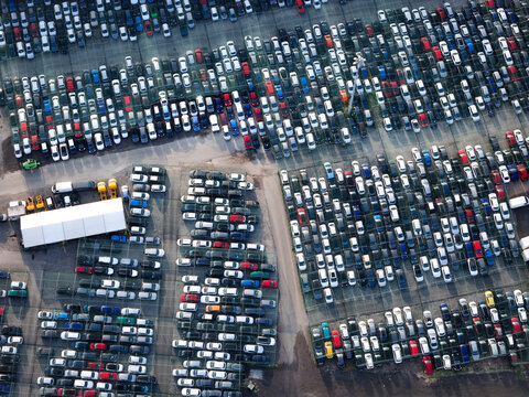 Aerial view of the car storage yard filled with rows of parked vehicles in Settimo Torinese, Piedmont, Italy.
