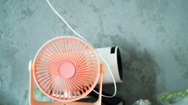 Portable mini USB fan blowing fresh air on office desk workspace