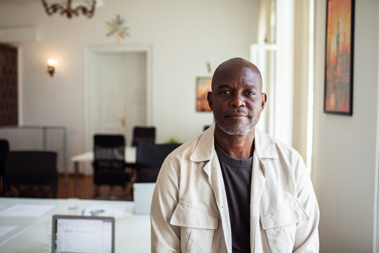 Business portrait of mature man in bright coworking office