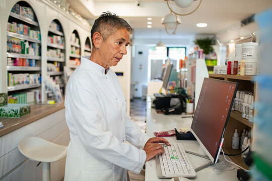 Pharmacist working on computer in pharmacy