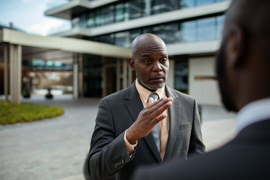 Businessman discussing strategy with colleague outside modern office