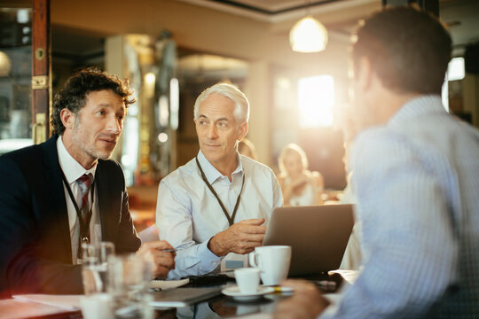 Business professionals meeting with laptop in cafe