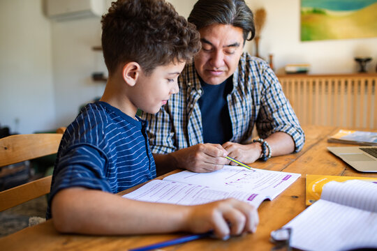 Father helping son with homework at home