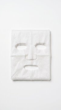 Stack of white cotton sheet masks for facial skincare treatment on a plain white background.