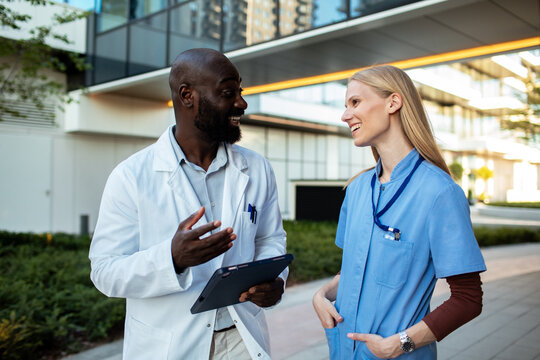 Doctor and nurse discussing patient care outside hospital