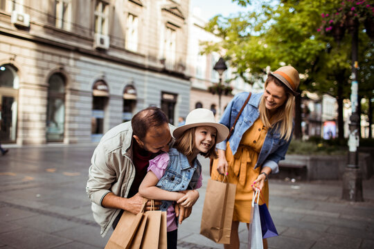 Happy family shopping together on city street