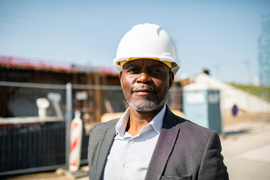 Confident construction manager in hard hat at building site