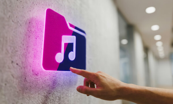 Hand touching a glowing music folder icon on a wall
