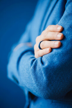 Person wearing a blue blazer with a blue ring on their finger