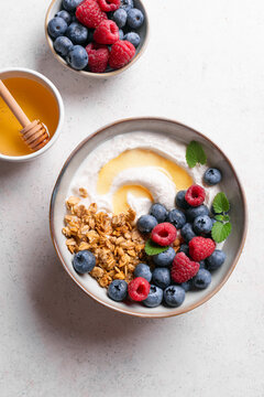Granola bowl with greek yogurt, berries and honey for healthy breakfast.