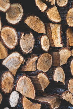 A rustic pile of neatly chopped firewood logs stacked high, ready for a cozy winter fireplace or outdoor fire pit