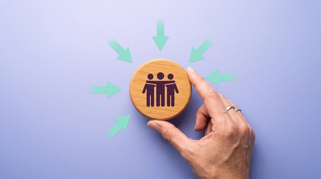 hand holding wooden token with people icons and arrows