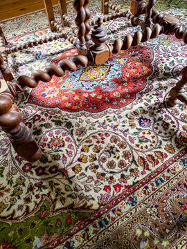 Persian wool rug with medallion under carved wooden table