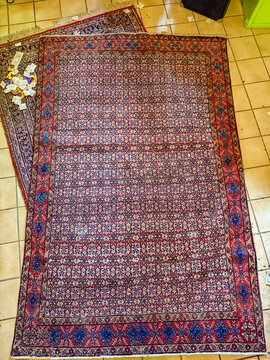 Antique Persian wool area rug on tiled floor